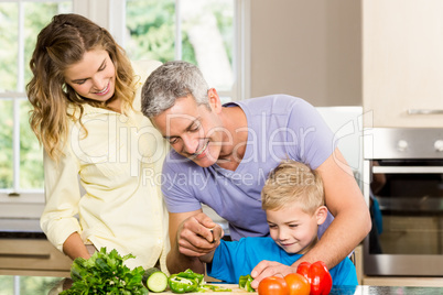 Happy family slicing vegetables