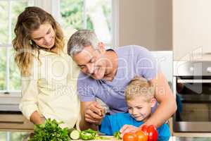 Happy family slicing vegetables