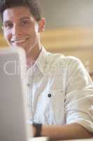 Smiling male student using laptop