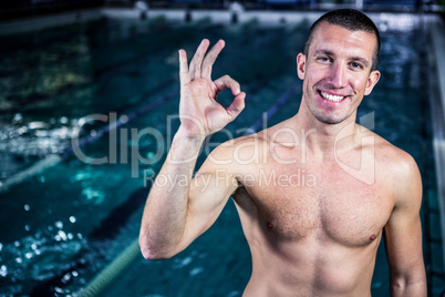 Fit smiling swimmer gesturing ok sign