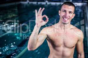 Fit smiling swimmer gesturing ok sign