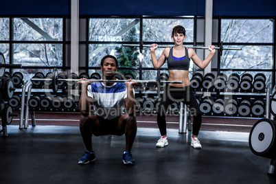 Fit couple exercising with barebell