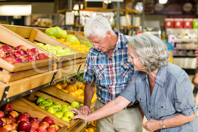 Smiling senior couple buying apples