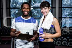 Male trainer and fit woman smiling