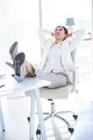 Businesswoman relaxing with legs on desk