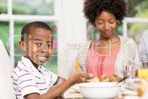 Smiling son eating his dinner