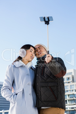 Couple making face and clicking pictures using selfie stick