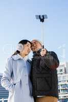 Couple making face and clicking pictures using selfie stick
