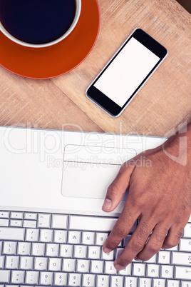 Businessman working on laptop with smart phone and coffee on des