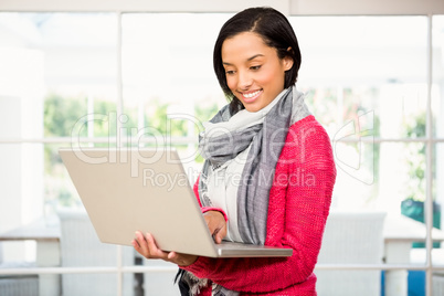 Smiling brunette using laptop