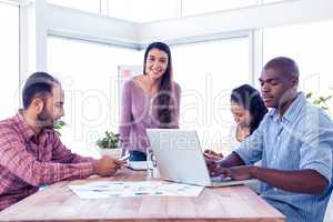 Portrait of smiling businesswoman with coworkers in conference r