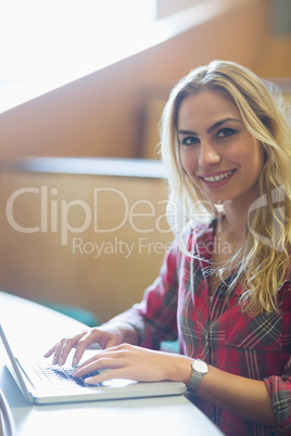 Smiling female student using laptop