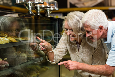 Senior couple pointing puddings