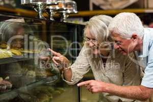 Senior couple pointing puddings
