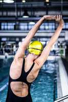 Swimmer woman stretching at edge of the swimming pool