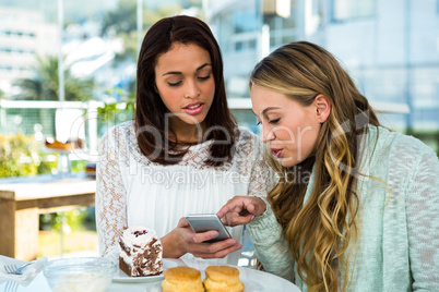 two girls watch a phone