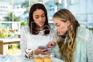 two girls watch a phone