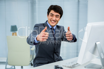 Smiling businessman showing thumbs up