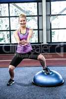 Fit woman doing exercise with bosu ball