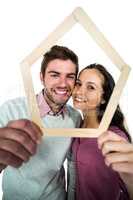 Portrait of smiling couple holding house shape