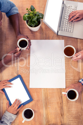 Business people using technologies while holding coffee cups