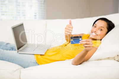 Smiling brunette showing credit card