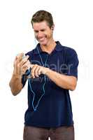 Cheerful man listening music while using mobile phone