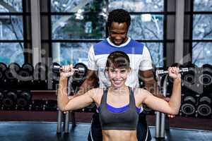 Male trainer assisting fit woman