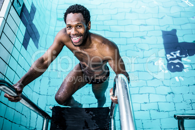 Smiling man getting out the pool