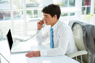 Busy asian businessman answering the phone