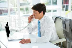 Busy asian businessman answering the phone