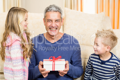 Happy father holding gift given by children