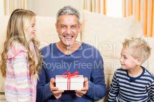 Happy father holding gift given by children