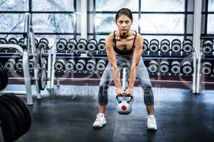 Serious fit woman lifting kettlebell