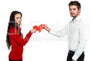 Portrait of couple holding red cracked heart shape