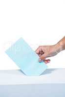 Businesswoman putting ballot in vote box