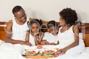 Happy family lying in bed together