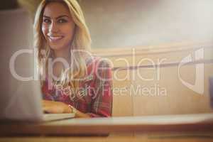 Smiling female student using laptop