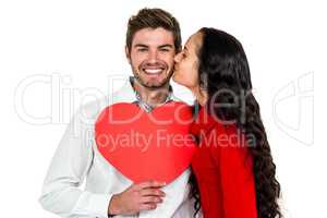 Man holding paper heart and being kissed by girlfriend