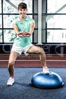 Fit woman doing exercise with bosu ball