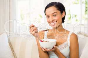 Attractive brunette eating cereals