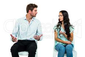 Couple sitting on chairs having argument