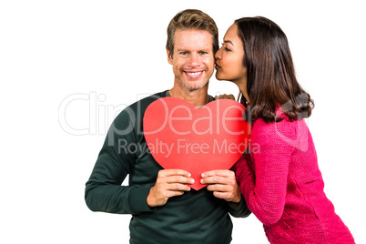 Woman kissing boyfriend with red heart shape