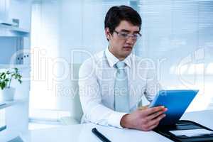 Serious asian businessman using his tablet