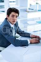 Tired businessman using his computer