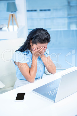 Worried businesswoman covering her face