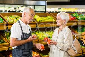 Senior customer and worker discussing vegetables
