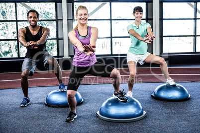 Fit people doing exercise with bosu ball