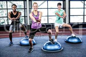 Fit people doing exercise with bosu ball