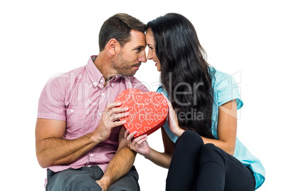 Happy couple holding heart shaped box